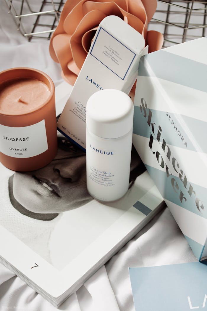 Skincare products and candle arranged in an elegant flat lay for beauty routines.